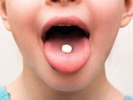 Child with pill on tongue