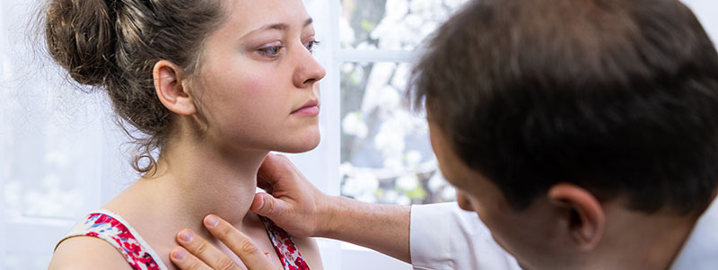 Doctor examining patient's thyroid