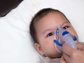 baby with oxygen mask
