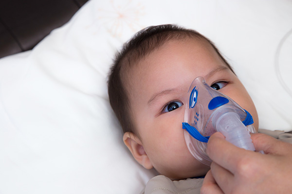 baby with oxygen mask