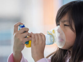 Girl using inhaler with spacer