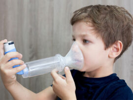 Boy with inhaler with spacer