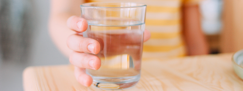 Child holding glass of water.